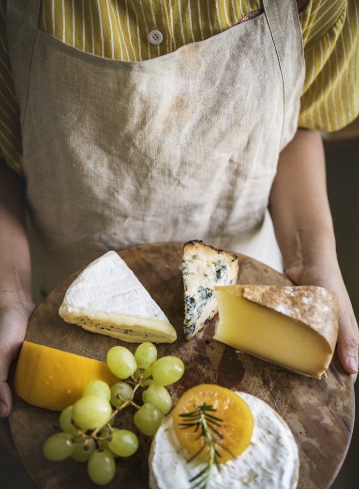 Holding a board of dairy-free cheeses