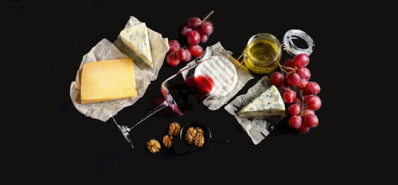 A dairy-free cheese platter with grapes, wine and honey